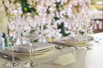 White card stands before diner plates and sparkling glasses