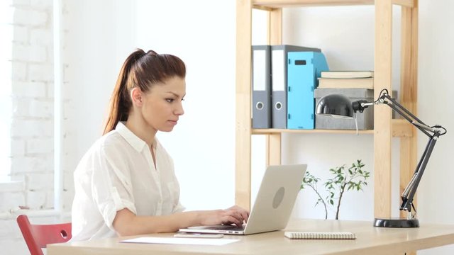 Woman Working On Laptop in Office