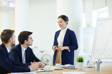 Businesswoman explaining financial data while teaching managers