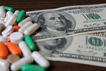Dollars and pills, a budget for treatment, expensive medications, drug prices in a pharmacy.