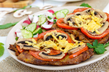 Chops baked with mushrooms, tomatoes and cheese on a white wooden background. Meat 