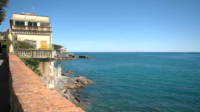House on a cliff facing the sea in Rapallo, Italy, on a sunny summer day.