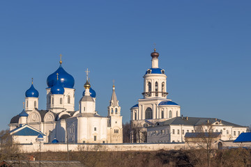 White-stone monastery with sky-blue domes at early spring