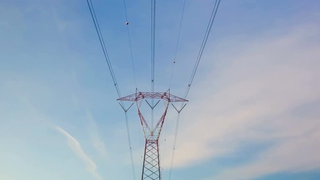 Red And White High Voltage Electricity Pylon Time Lapse on a Blue Cloudy Sky