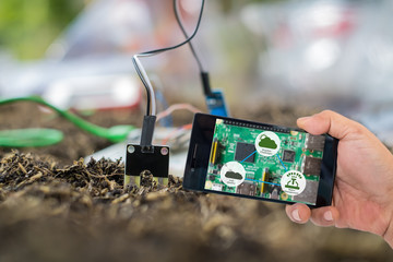 Agricultural technology and organic agriculture concept. Smart farmer holding smart phone with...