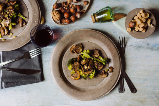 Overhead view of sauteed mushrooms with  broccoli served on concrete plate