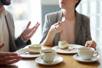 Fototapeta na wymiar Two humans having tasty dessert and talking in cafe