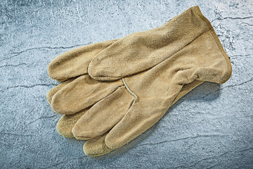 Leather safety gloves on metallic background building concept