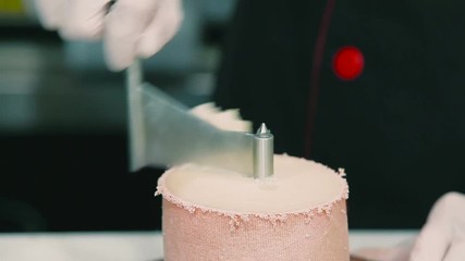 The male's hands cutting the cheese in flowers on special equipment