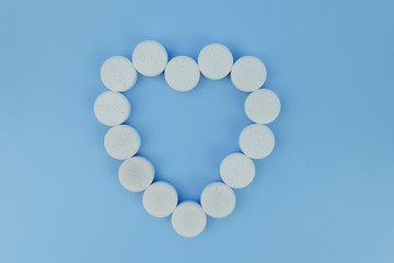 white pills on the soft blue background with soft focus style. paracetamol 500 mg.