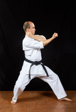 On a black background, the master trains karate blocks