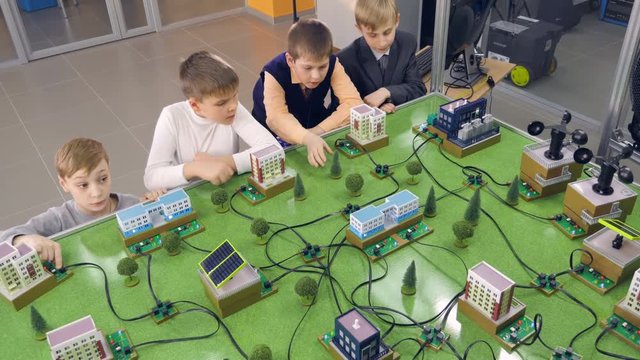 Elementary school students doing study alternative energy project on a city prototype.