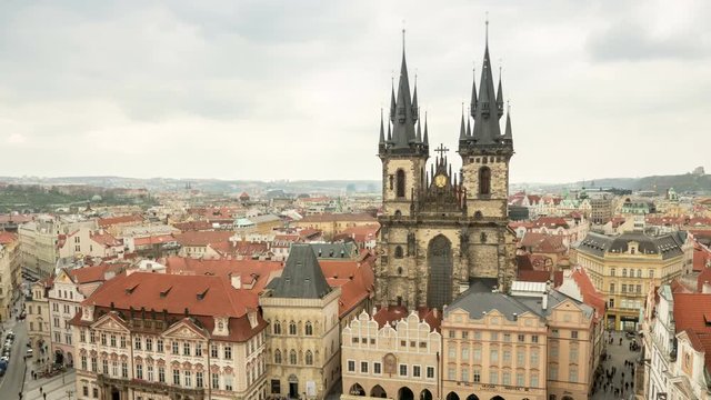 Old Town Hall with itsgothic towers, historic multistoreyed  buildings, covered with red tile, impressive view,  rushing back and forth tourists, in the daytime in spring, taken  as a timelapse shot