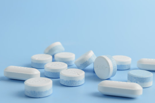 white pills on the soft blue background with soft focus style. paracetamol 500 mg.