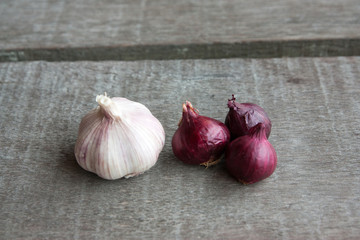 Garlic and red onion on wood background