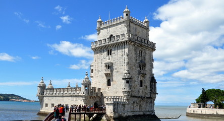 Torre de Belém vor strahlend blauem Himmel und Fußgängerbrücke