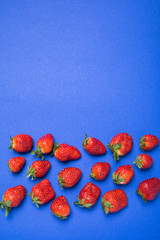 top view of fresh red strawberries isolated on blue with copy space, berries background concept