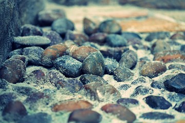 Stones and pebble on ground closeup in garden background
