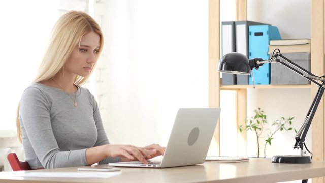 Young Woman Working On Laptop in Office