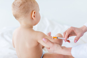 Cropped shot of medical worker making injection for cute baby boy, 1 year old baby concept