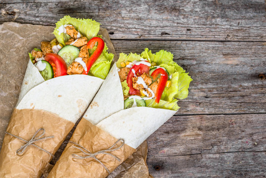 Delicious tortilla wraps, burritos filled with grilled chicken and vegetables, mexican cuisine fast food, top view