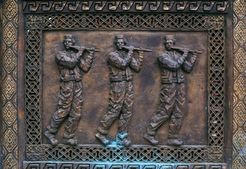 Bronze carving relief with three men figures in traditional Macedonian folkloric dresses