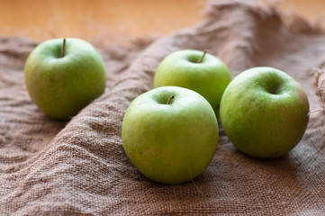 Green apples on the sackcloth texture background