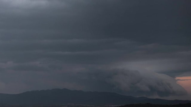 Spectacular clouds slithering over mountain range time lapse