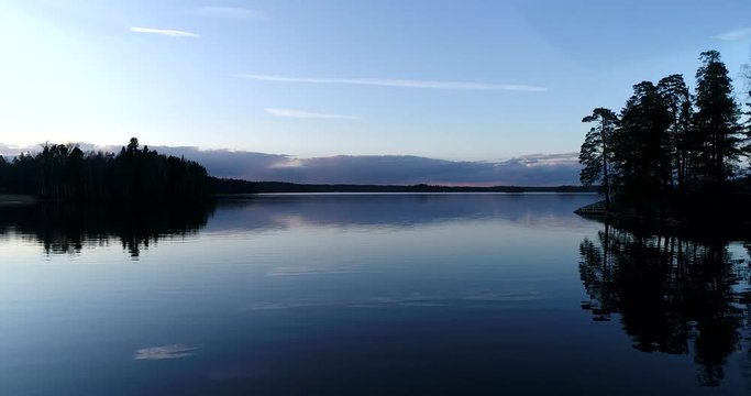 Lake bodom, Cinema 4k aerial flight above mirroring bodom lake, on a sunny spring evening, in Espoo, Finland