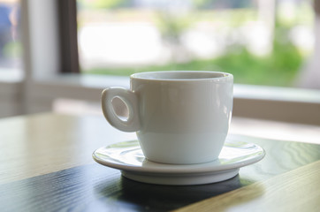 A cup of black coffee in a white cup on wooden table