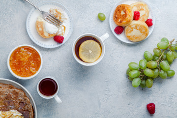 Morning atmosphere. Healthy breakfast with porridge, oatmeal, pancakes, lots of berries and snacks on blue rustic background. Copy space