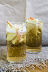 Apple cider with slices of apples in transparent glasses on a wooden board