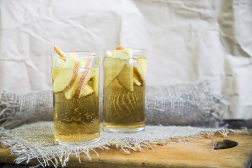 Apple cider with slices of apples in transparent glasses on a wooden board
