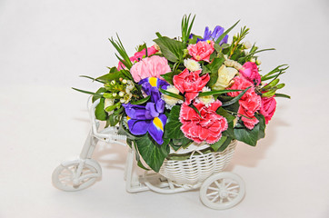 Floral arrangement with white bicycle and colored flowers roses, iris, chrysanthemums, Carnations, isolated