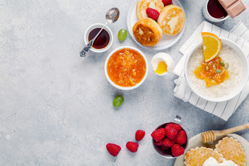 Morning atmosphere. Healthy breakfast with porridge, oatmeal, pancakes, lots of berries and snacks on blue rustic background. Copy space