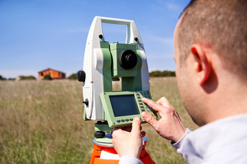 Man using of total station. Guy surveyor at work. Survey Instrument geodetic device, total station...