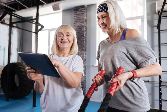 Happy energetic woman pointing at the tablet screen