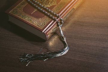 Islam holy book of Muslims, the Quran, holy book on a wooden black background.