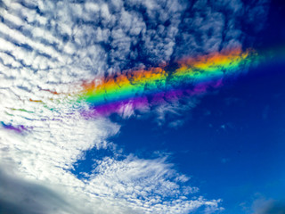 Fototapeta na wymiar rainbow inside white cloud on the sky