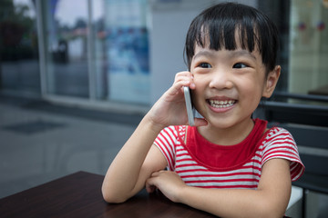 Asian Chinese little girl playing smartphone