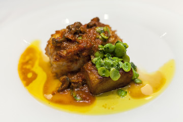 Monkfish with red sauce and broad ben in a dish.