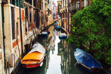 Canals in Venice, Italy. Boats moored in front of the houses