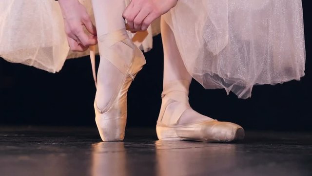 Unrecognised ballerina putting on pointer shoes. Close-up. HD.