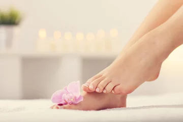 Fototapete Rund Weiche weibliche Füße mit französischer Pediküre und Blumen hautnah © Kalim