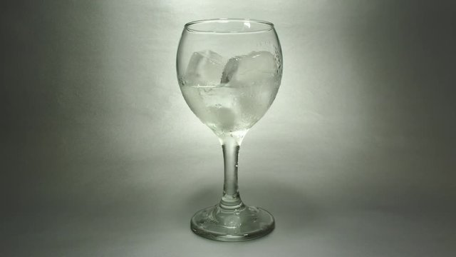 ice cubes melting in a wine glass, time lapse