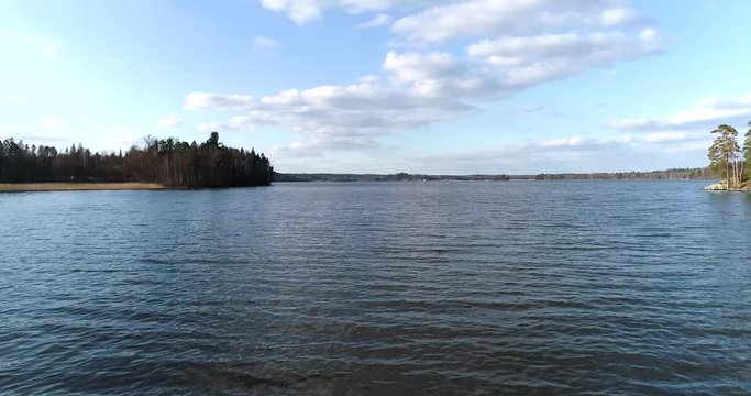 Lake bodom, Cinema 4k aerial flight up and revealing the bodom lake, on a sunny spring day, in Espoo, Finland
