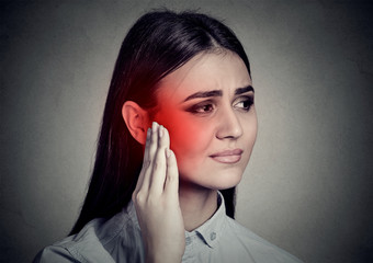 Tinnitus. Sick woman having ear pain touching her temple