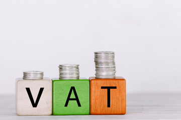 VAT Concept with wooden block with stacked coins