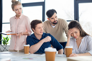 group of young business people looking at colleague on small business meeting
