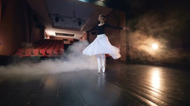 Beautiful ballerina girl turning around, dancing in theatre. Steadicam. HD.